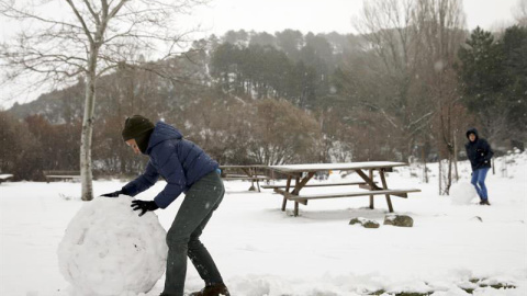 Un niño juega con la nieve en un área recreativa próxima a la localidad de Robledondo, en la sierra norte de Madrid. / BALLESTEROS (EFE) Un niño juega con la nieve en un área recreativa próxima a la localidad de Robledondo, en la sierra norte de Madrid. / BALLESTEROS (EFE)