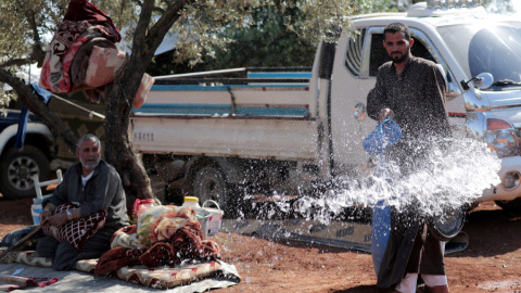 Un sirio desplazado vierte agua en un olivar en la ciudad de Atmeh, en la provincia siria de Idlib. REUTERS / Khalil Ashawi