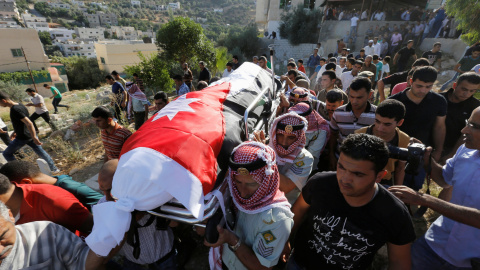 Doldados jordanos y familiares de Belal Al- Zuhbe , uno de los soldados muertos en un ataque contra un puesto militar fronterizo cerca de un campamento de refugiados sirios , llevan su cuerpo durante su funeral en el pueblo de Nahleh.- REUT