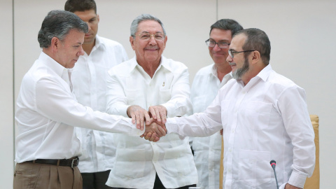El presidente de Colombia, Juan Manuel Santos, se da la mano con el jefe de las FARC, Rodrigo Londoño 'Timochenko', en presencia del presidente de Cuba, Raúl Castro. - REUTERS El presidente de Colombia, Juan Manuel Santos, se da la mano con el jefe de las FARC, Rodrigo Londoño 'Timochenko', en presencia del presidente de Cuba, Raúl Castro. - REUTERS