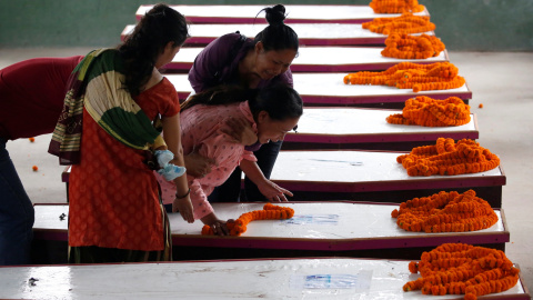 Los familiares lloran cerca de ataúdes que contienen los cuerpos de los nacionales de Nepal , que murieron cuando bombardero suicida hizo minibús en Kabul , en fila después de haber volado desde Afganistán en el aeropuerto internacional de 