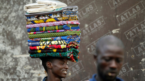 Un hombre vende telas sin coser conocidas localmente como "Ankara " camina en Lagos, Nigeria. REUTERS / Akintunde Akinleye