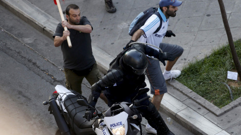 Un manifestante intenta golpear a un agente en las inmediaciones de la plaza Syntagma. - REUTERS