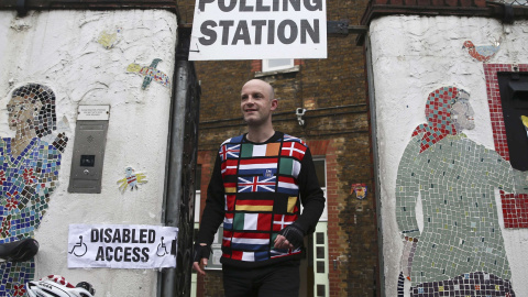 Un chico con un jersey con banderas europeas y una pegatina que dice "I'm in" ('estoy dentro') sale del colegio electoral en Reino Unido/REUTERS