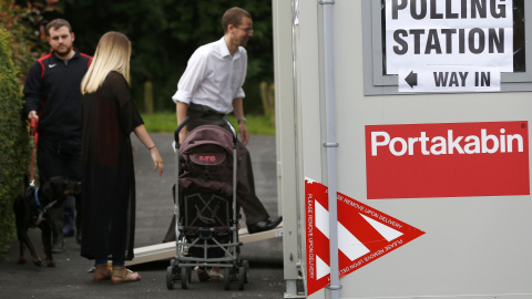 Tres personas acuden a votar a uno de los puntos móviles de votación en Reino Unido/REUTERS