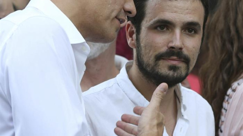 El secretario general del PSOE, Pedro Sánchez (i), conversa con el diputado de IU Alberto Garzón (d), al comienzo del tradicional desfile del Orgullo Gay.- EFE