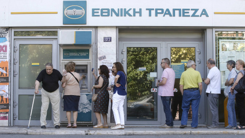 Algunos atenientes hacen cola en un cajero -el límite de 60 euros por día sigue vigente- donde lucen carteles a favor del 'No' en referéndum. REUTERS/Christian Hartmann