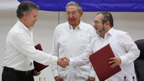 De izquierda a derecha, Juan Manuel Santos, presidente de Colombia, estrecha la mano del líder guerrillero Rodrigo Londono, más conocidad por su nombre de guerra, 'Timochenko'. Todo ello ante el presidente de Cuba, Raúl Castro. / REUTERS De izquierda a derecha, Juan Manuel Santos, presidente de Colombia, estrecha la mano del líder guerrillero Rodrigo Londono, más conocidad por su nombre de guerra, 'Timochenko'. Todo ello ante el presidente de Cuba, Raúl Castro. / REUTERS