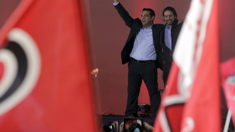 El líder del partido español Podemos, Pablo Iglesias, saluda acompañado por el líder de Syriza, Alexis Tsipras. EFE/Yannis Kolesidis