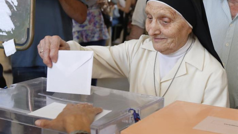 Una monja deposita su voto en un colegio del barrio de Aravaca, en Madrid