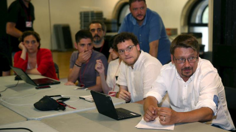 El candidato de En Comú Podem, Xavier Doménech, y dirigentes de la formación, entre ellos la alcaldesa de Barcelona, Ada Colau, siguen los primeros sondeos de la televisión en la Estació del Nord, donde pasarán la noche electoral. EFE/Toni 