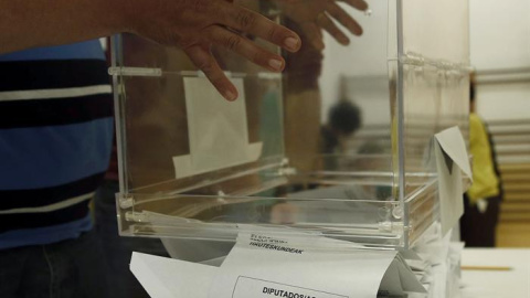El presidente de una mesa electoral de Pamplona esparce los votos al Congreso de los Diputados para proceder a su recuento al cierre del colegio electoral. EFE/Jesús Diges.