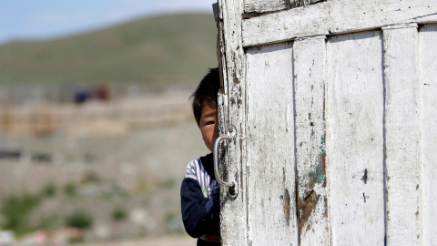 Un niño de cinco año se esconde tras una puerta en un pueblo de Mongolia. REUTERS/Jason Lee