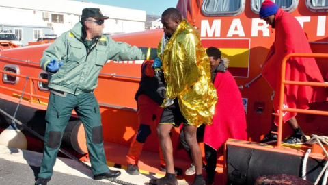Un agente de la Guardia Civil ayudando a los 36 inmigrantes de origen subsahariano que viajaban en una patera y que han sido rescatados a 11 millas de la isla de Alborán por Salvamento Marítimo. EFE/Alba Feixas Un agente de la Guardia Civil ayudando a los 36 inmigrantes de origen subsahariano que viajaban en una patera y que han sido rescatados a 11 millas de la isla de Alborán por Salvamento Marítimo. EFE/Alba Feixas