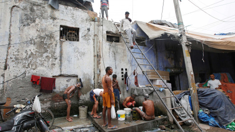 Trabajadores toman un baño y lavan sus ropas en una fuente municipal en Nueva Delhi, India. REUTERS/Adnan Abidi