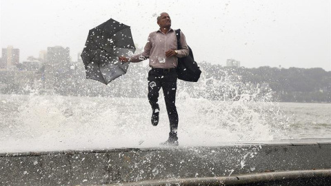 Una ola golpea a un indio durante la marea alta en el paseo marítimo de Bombay, India. El ochenta por ciento de las precipitaciones totales en la India se recogen durante el paso del monzón, de junio a septiembre. EFE/Divyakant Solanki
