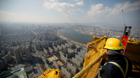 Un trabajador de la construcción se asoma desde el piso 99 de la torre Mundial Lotte en Seúl.-  REUTERS / Kim Hong - Ji / Foto Archivo