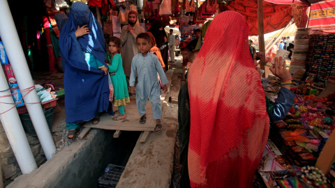 Una mujer afgana , vestida con un burka , realiza compras en un mercado de Peshawar , Pakistán.- REUTERS / Fayaz Aziz