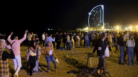 15/05/2021. Varios jóvenes recogen sus pertenencias en la playa de la Barceloneta mientras la Policía desaloja la zona, este sábado en Barcelona. - EFE 15/05/2021. Varios jóvenes recogen sus pertenencias en la playa de la Barceloneta mientras la Policía desaloja la zona, este sábado en Barcelona. - EFE