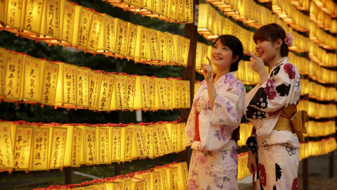 Dos mujeres ataviadas con trajes tradicionales partician en la festividad de verano de Mitama Matsuri en el templo de Yasukuni en Tokio (Japón). Cerca de 300.000 personas participan en esta festividad de tres días que se celebra para honrar