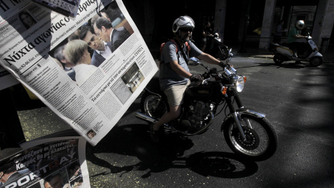 Un motorista pasa junto a un quiosco de prensa en el centro de Atenas (Grecia) hoy. EFE/Orestis Panagiotou