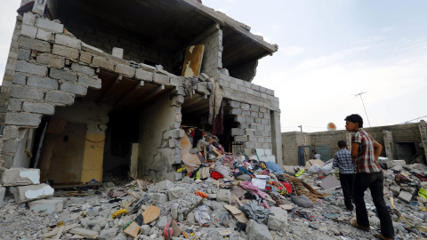 Un par de jóvenes observan los escombros de un edificio tras un bombardeo en Saná (Yemen). Al menos 21 personas, entre ellas niños y mujeres, murieron esta madrugada y otras 45 resultaron heridas en ataques aéreos de la coalición árabe en u
