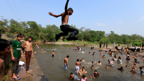 Un hombre salta al agua para refrescarse del calor en un día caluroso de verano en Islamabad , Pakistán.-REUTERS / Faisal Mahmood