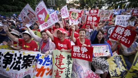 Varios manifestantes gritan consignas y sostienen carteles en los que se lee "No a la guerra" durante una protesta en contra de la nueva legislación sobre seguridad cerca del Parlamento en Tokio, Japón, hoy 14 de julio de 2015. EFE/Franck R