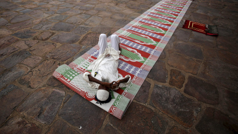 Un hombre musulmán descansa mientras espera a orar esta noche y romper su ayuno durante el mes sagrado del Ramadán en las ruinas de la mezquita Feroz Shah Kotla en Nueva Delhi 14 de julio de 2015. REUTERS / Anindito Mukherjee