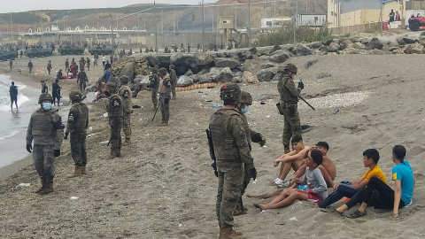 Miembros del Ejército observan a un grupo de inmigrantes que ha llegado a nado en los espigones fronterizos de Ceuta este martes 18 de mayo de 2021. Miembros del Ejército observan a un grupo de inmigrantes que ha llegado a nado en los espigones fronterizos de Ceuta este martes 18 de mayo de 2021.
