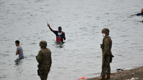 Militares del ejército español vigilan durante las devoluciones en caliente que están efectuando a los migrantes que han entrado en Ceuta procedente de Marruecos, a 18 de mayo de 2021, en Ceuta, (España). Militares del ejército español vigilan durante las devoluciones en caliente que están efectuando a los migrantes que han entrado en Ceuta procedente de Marruecos, a 18 de mayo de 2021, en Ceuta, (España).