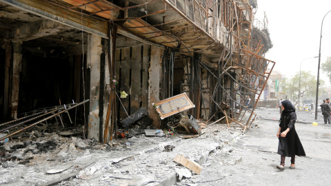 Una niña camina frente a un edificio dañado tras un ataque suicida con coche bomba en la zona comercial de Karrada , un distrito mayormente chiíta , en Bagdad , Iraq.- REUTERS / Ahmed Saad