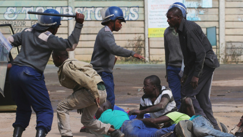 Policías antidisturbios cargan contra los residentes del barrio de Epworth después de que una protesta de taxistas se tornó violenta en Harare, Zimbabwe.-REUTERS / Philimon Bulawayo TPX IMÁGENES DEL DÍA