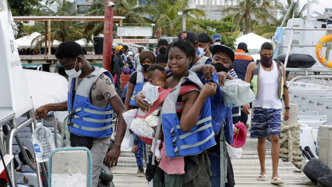 Migrantes de diversas partes del mundo esperan para abordar una embarcación que los lleve al otro lado del golfo de Urabá, el 3 de mayo de 2021, en Necoclí (Colombia). Migrantes de diversas partes del mundo esperan para abordar una embarcación que los lleve al otro lado del golfo de Urabá, el 3 de mayo de 2021, en Necoclí (Colombia).