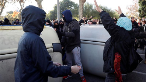 Manifestantes independentistas encapuchados vuelcan contenedores en las inmediaciones de la Llotja de Mar de Barcelona/EFE