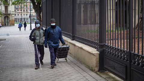 Una persona ciega camina junto a otra. 2020. Una persona ciega camina junto a otra. 2020.