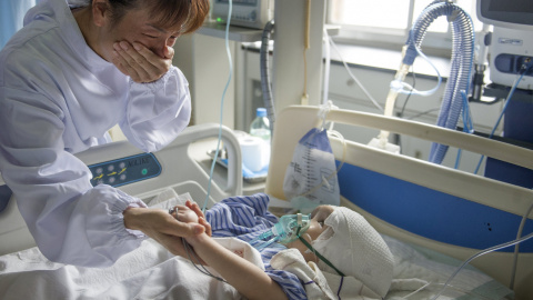 Hanhan, de tres años, después de una cirugía para implantar tres piezas de titanio para reemplazar su cráneo, con su tía, que llora mientras sostiene su mano en un hospital en Changsha, provincia de Hunan, China, 15 de julio 2015. REUTERS/S