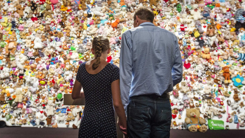 Dos personas observan los peluches dejados en memoria de las víctimas del avión de Malaysian Airlines que, con 298 pasajeros a bordo la mayoría ciudadanos holandeses, fue derribado hace un año en el este de Ucrania, en Nieuwegein, Holanda, 