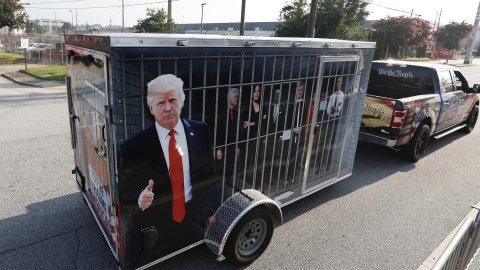 Un seguidor del expresidente estadounidense Donald Trump con un remolque que muestra imágenes de líderes demócratas en una celda, a las puertas de la cárcel del condado de Fulton, en Atlanta, Georgia, este 24 de agosto de 2023. Un seguidor del expresidente estadounidense Donald Trump con un remolque que muestra imágenes de líderes demócratas en una celda, a las puertas de la cárcel del condado de Fulton, en Atlanta, Georgia, este 24 de agosto de 2023.