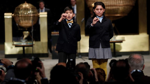 Nerea Pareja Martínez y Alonso Dávalos Durán, primera pareja de niños en el sorteo Extraordinario de la lotería Navidad, muestran el segundo premio del sorteo. /EFE Nerea Pareja Martínez y Alonso Dávalos Durán, primera pareja de niños en el sorteo Extraordinario de la lotería Navidad, muestran el segundo premio del sorteo. /EFE