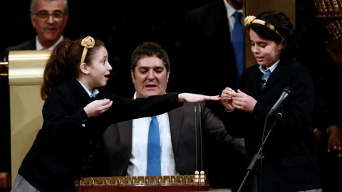 Las niñas de San Ildefonso Aya Ben Hamdouch y Carla García Villnueva en el momento de cantar que número 03.347 ha sido agraciado con el primer premio, el Gordo, dotados con 400.000 euros al décimo, en el Sorteo de la Lotería de Navidad que 