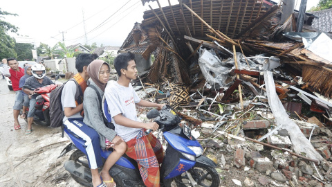Varios residentes locales de Anyar transitan en moto cerca de una zona devastada por el tsunami de Indonesia.- EFE/EPA/ADI WEDA