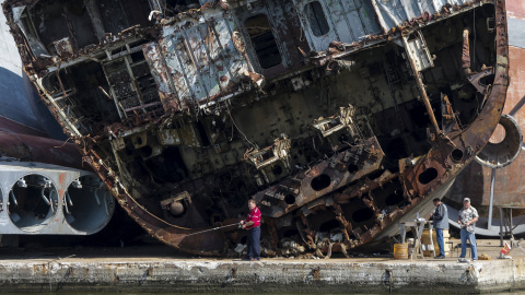 Varios hombres pescan en frente de barcos destrozados en la base de la flota rusa en Baltiysk, en la región de Kaliningrado, Rusia. Kaliningrado será una sede de la Copa Mundial 2018. REUTERS / Maxim Shemetov