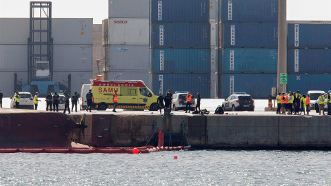 Efectivos de la Guardia Civil y del servicio de emergencias esperan en el Muelle del Centenario de Port Castelló durante las tareas de búsqueda de dos personas desaparecidas tras el vuelco del buque "Nazmuye Ana" (a la izquierda, en la imag Efectivos de la Guardia Civil y del servicio de emergencias esperan en el Muelle del Centenario de Port Castelló durante las tareas de búsqueda de dos personas desaparecidas tras el vuelco del buque "Nazmuye Ana" (a la izquierda, en la imag