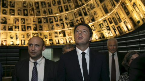 El primer ministro italiano Matteo Renzi (D) se encuentra con el ministro de Educación Naftali Bennett de Israel mientras mira fotos de judíos asesinados en el Holocausto, en una visita a la Sala de los Nombres en la Historia del Holocausto