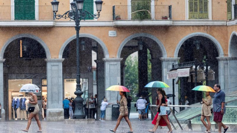 Varias personas se protegen con paraguas de la lluvia en la Plaza Mayor de Palma de Mallorca. /EFE Varias personas se protegen con paraguas de la lluvia en la Plaza Mayor de Palma de Mallorca. /EFE