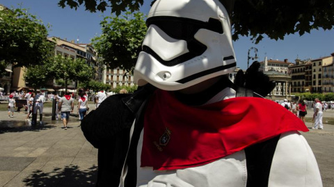 Un hombre disfrazado de soldado del Imperio Galáctico de Star Wars se coloca el tradicional pañuelico rojo al cuello para sumarse a la fiesta durante los Sanfermines 2016. EFE/Villar López.