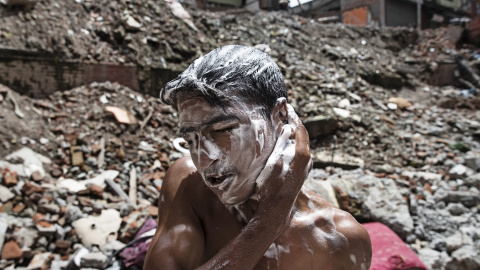 Un joven nepalí se lava la cabeza en Thamel, Katmandú (Nepal) hoy, 23 de julio de 2015. Tras los graves destrozos causados por el terremoto que asoló Nepal el pasado mes de abril los locales se enfrentan a dificultades diarias para acceder 