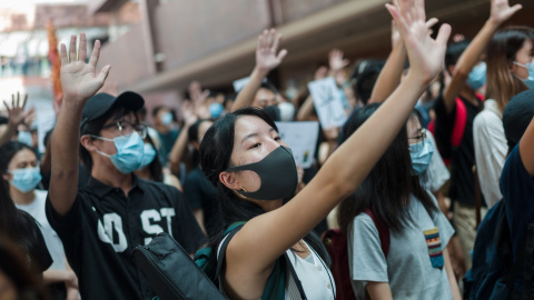 Varias docenas de estudiantes que vestían camisas negras y máscaras instaron al gobierno de Hong Kong a aceptar las cinco demandas de los activistas contra la extradición, incluida una investigación sobre la presunta brutalidad policial y e Varias docenas de estudiantes que vestían camisas negras y máscaras instaron al gobierno de Hong Kong a aceptar las cinco demandas de los activistas contra la extradición, incluida una investigación sobre la presunta brutalidad policial y e