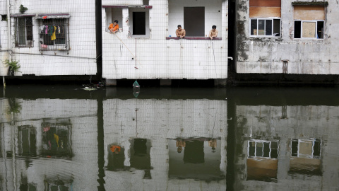 La gente pescando desde un piso abandonado en el pueblo de Xian, un barrio pobre en el centro de Guangzhou, China, 24 de julio de 2015. REUTERS / Tyrone Siu